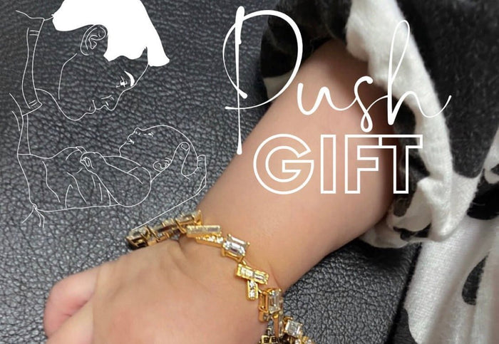 赤ちゃんの手首にゴールドのブレスレットを添えたPush GIFTの文字入り画像