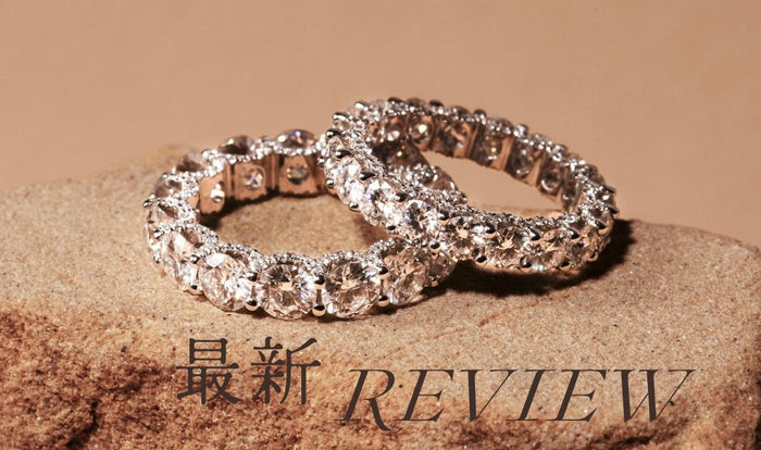 石の上に置いた2本のフルエタニティリングと「最新REVIEW」の文字