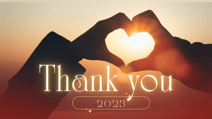 夕焼けを背景に手でつくったハートと「Thank you 2023」の文字