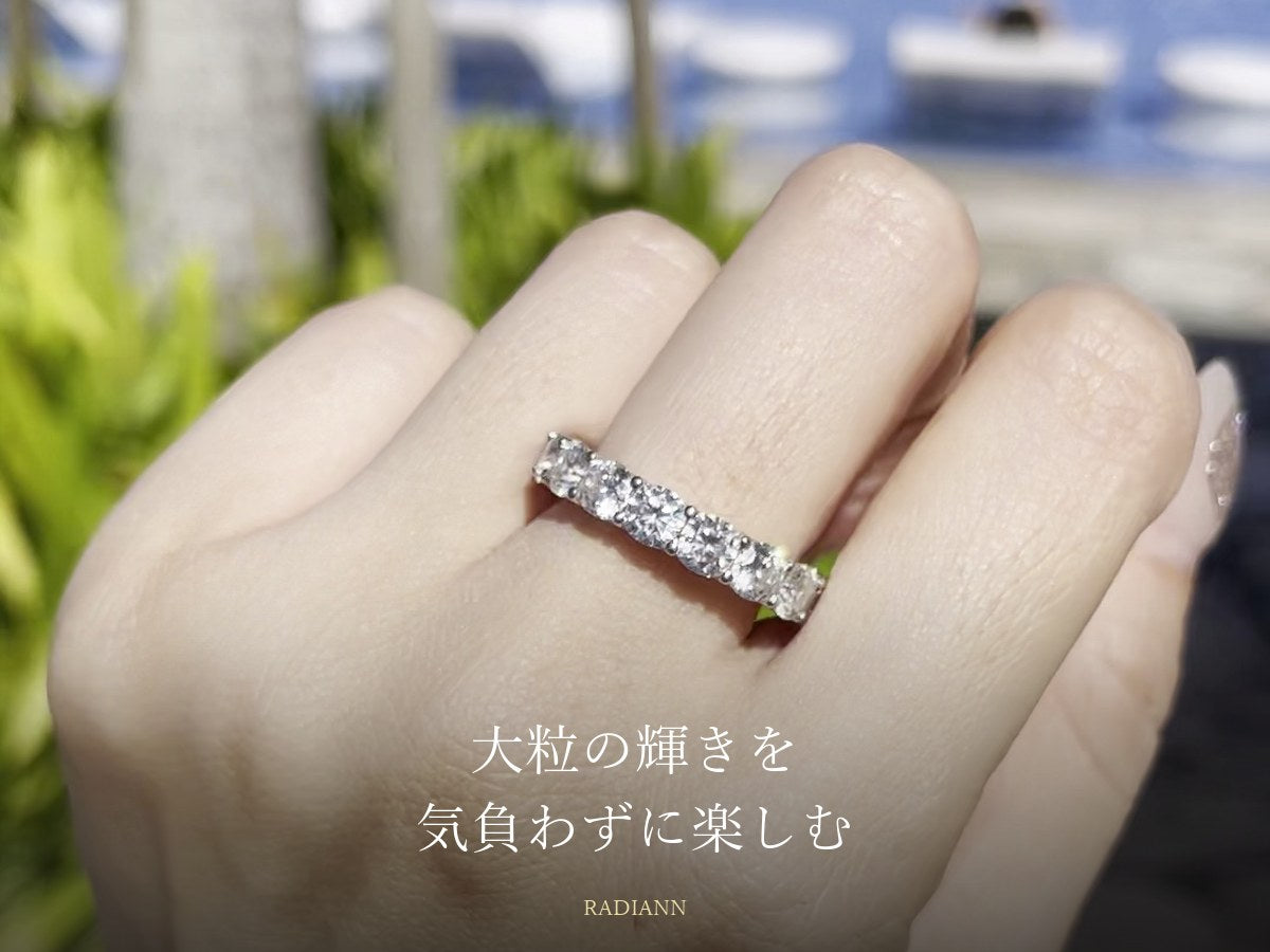 リゾートのプールサイドで大粒のモアサナイトのエタニティリングを着けた手元