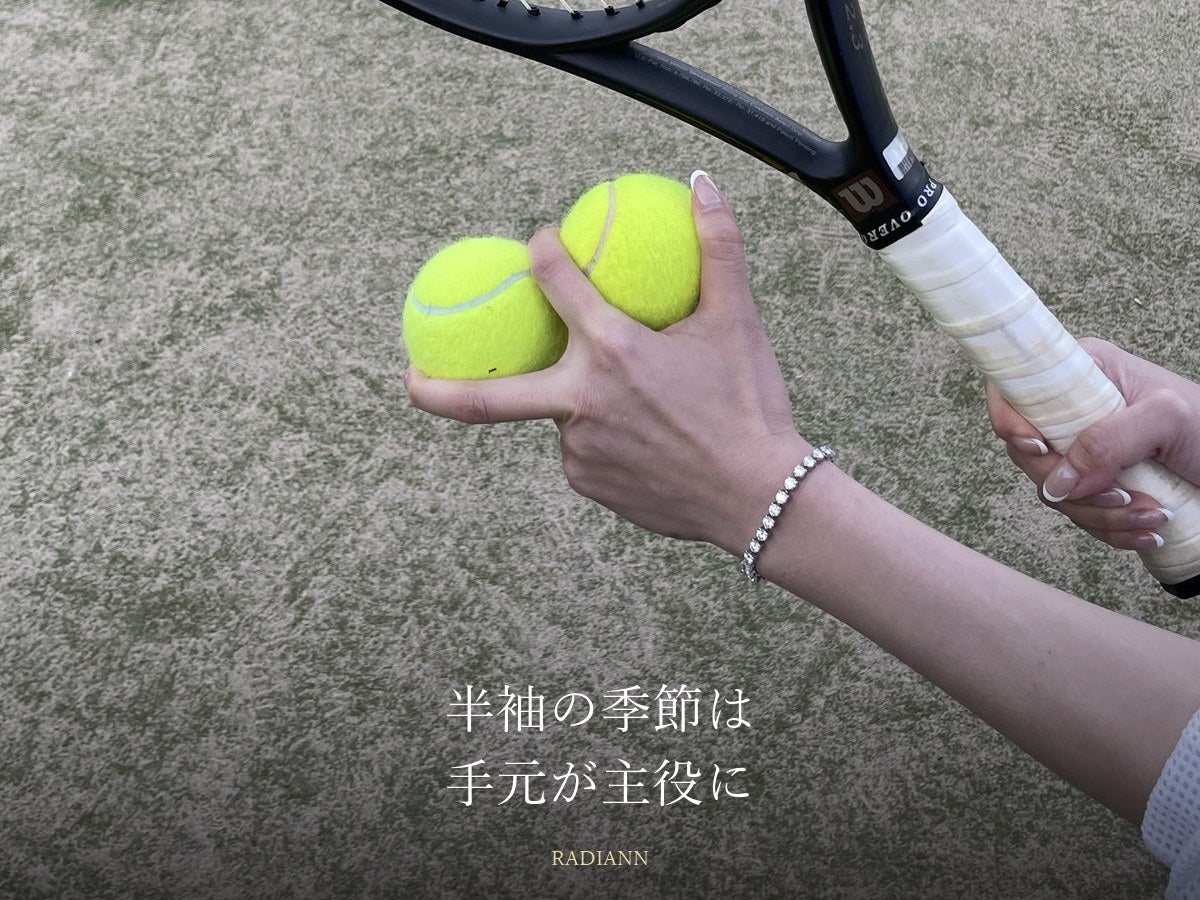 テニスボールを持つ手首に着けたモアサナイトのテニスブレスレット